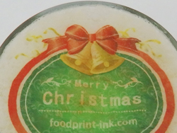 カフェラテにクリスマスのデザインを印刷した透明可食シートをのせてビアアート